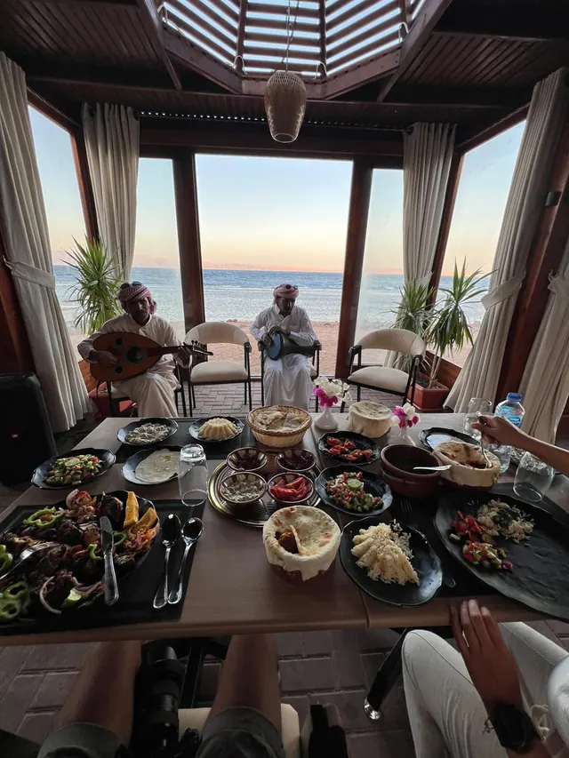 Bedouin musicians and Egyptian dishes at a seaside table